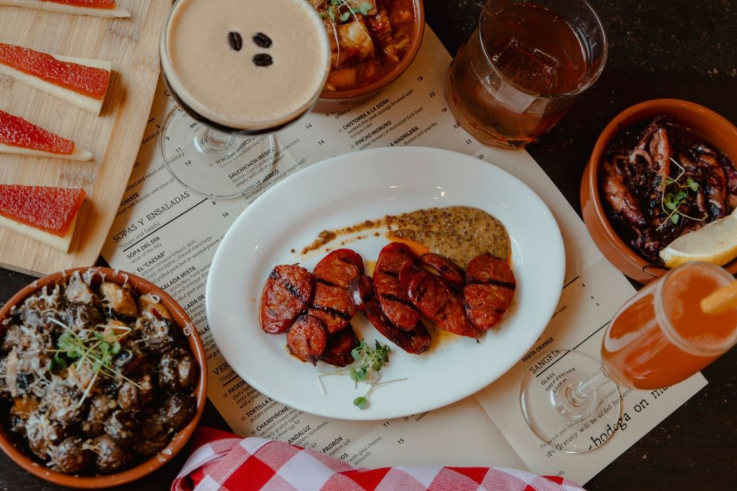 A plate of chorizo sausage and some other tapas.